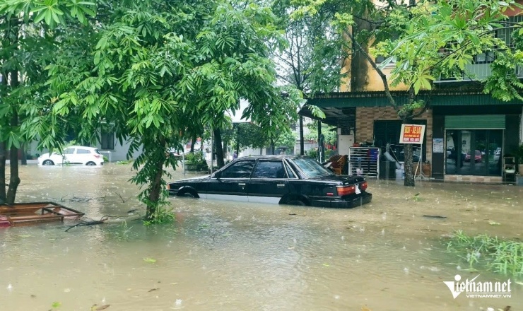 Nước lên nhanh khiến nhiều người không kịp cho xe lên cao. Ảnh: Lê Dương