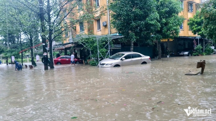 Xe ô tô này mặc dù đã được đưa lên vỉa hè nhưng vẫn bị nước ngập gần hết bánh. Ảnh: Lê Dương