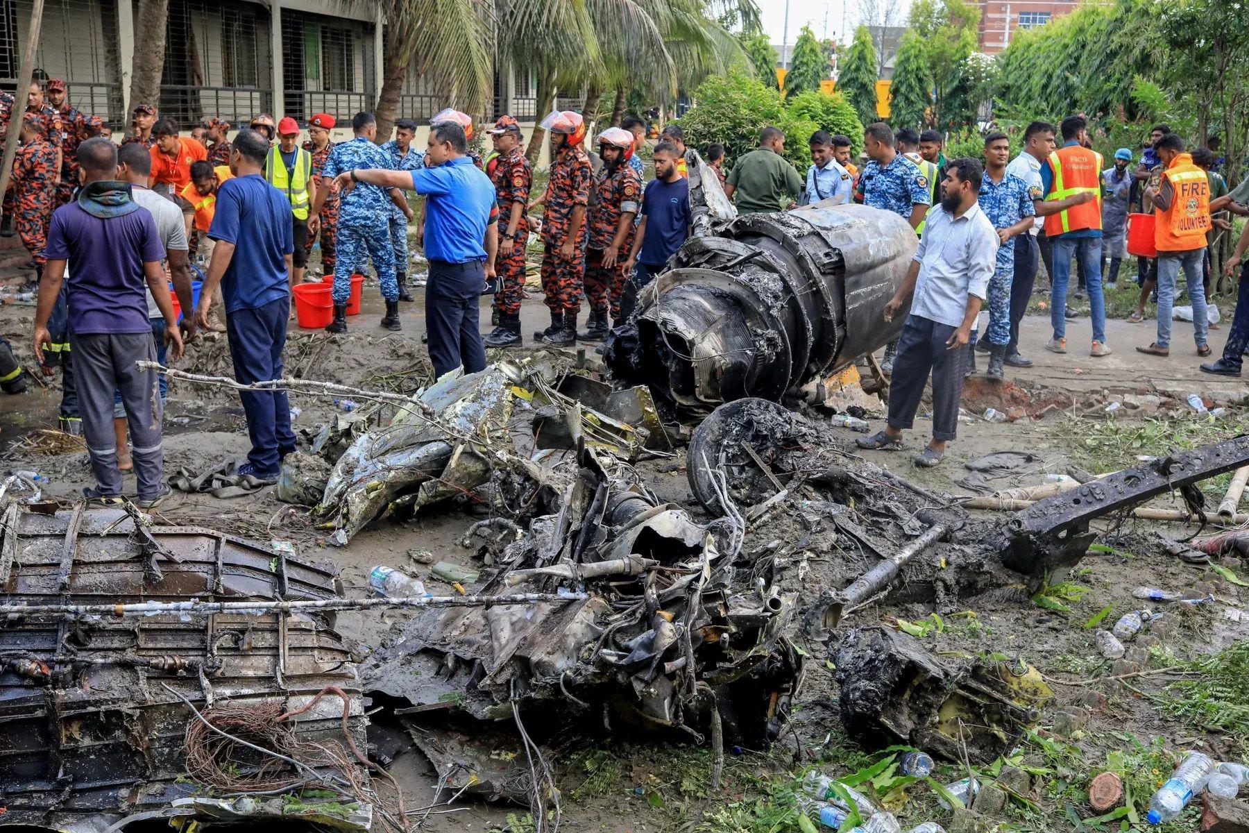 Một phần xác chiếc tiêm kích F-7BGI được đưa ra khỏi trường học (ảnh: Jubair Bin Iqbal/AFP/Getty Images)