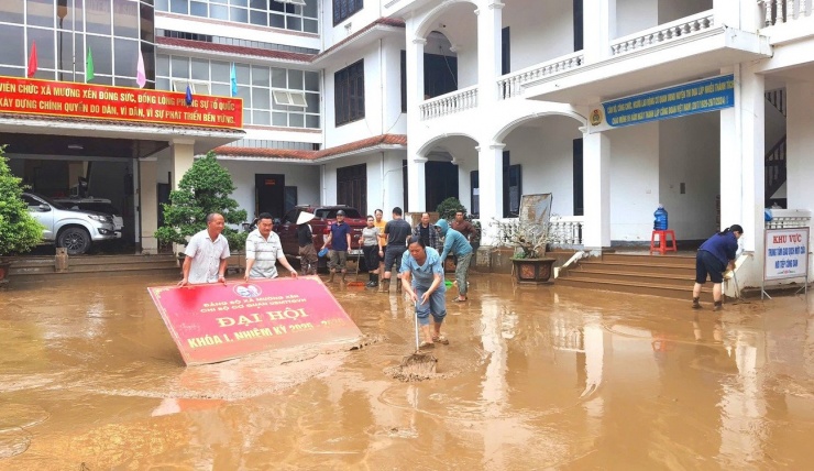 Cán bộ xã Mường Xén thu dọn tài sản, dọn bùn đất khi nước lũ rút đi.