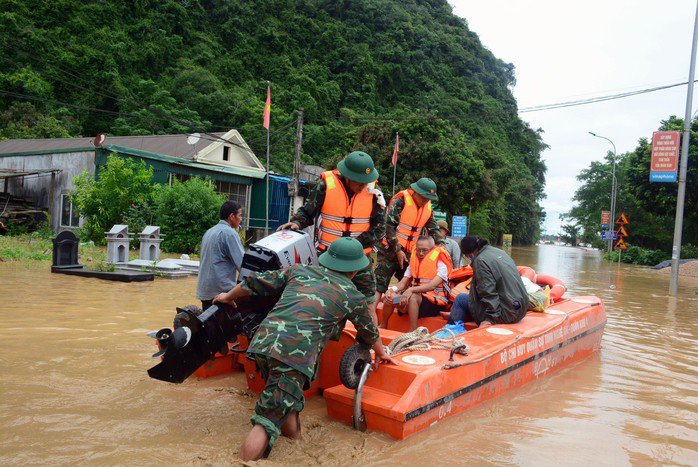 Lực lượng chức năng sơ tán người dân tại vùng bị ngập sâu. Ảnh: M. Tuấn