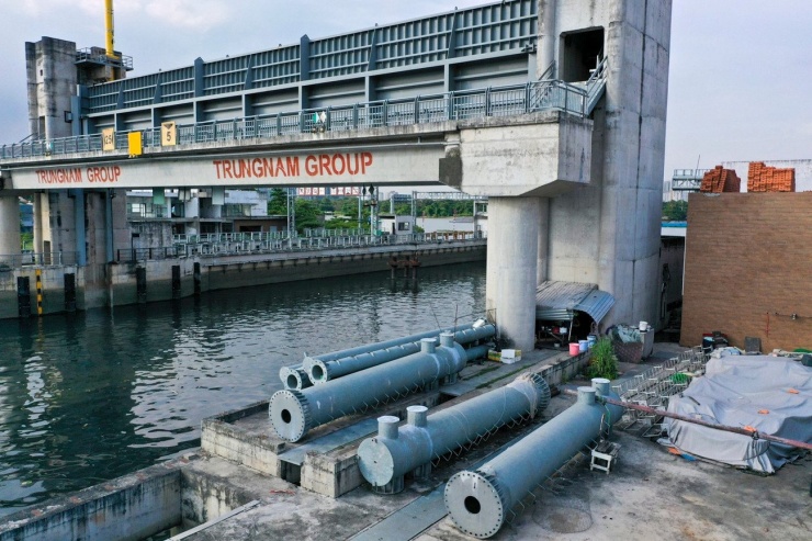 Trụ, ống, vật liệu xây dựng nằm ngổn ngang, chất thành đống bên trong dự án.