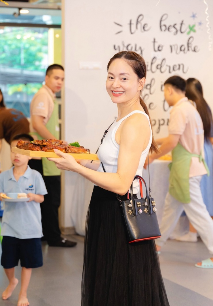 Bà mẹ hai con tươi tắn khi tham gia sự kiện cộng đồng.