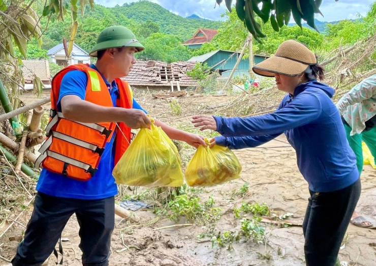 Bí thư Đảng ủy xã Tương Dương Lê Văn Lương cùng các lực lượng tiếp tế nhu yếu phẩm cần thiết cho người dân vùng lũ.
