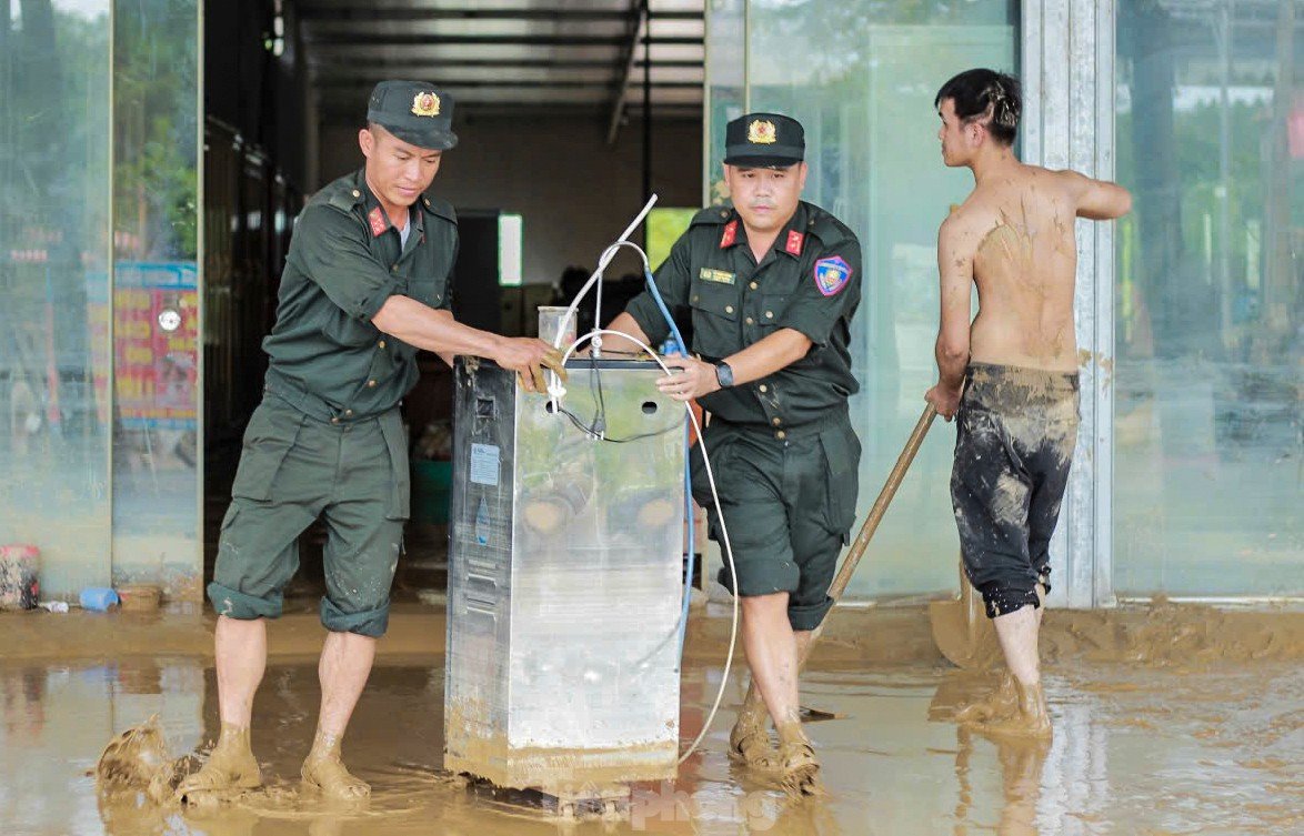 Cảnh sát cơ động lội bùn, giúp dân dọn dẹp sau lũ - 7