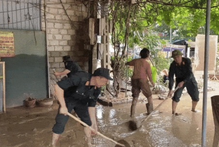 Cảnh sát cơ động lội bùn, giúp dân dọn dẹp sau lũ