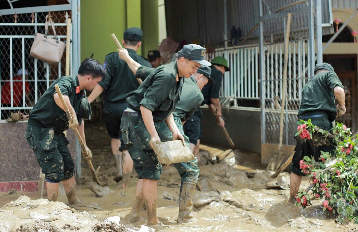 Cảnh sát cơ động lội bùn, giúp dân dọn dẹp sau lũ - 11
