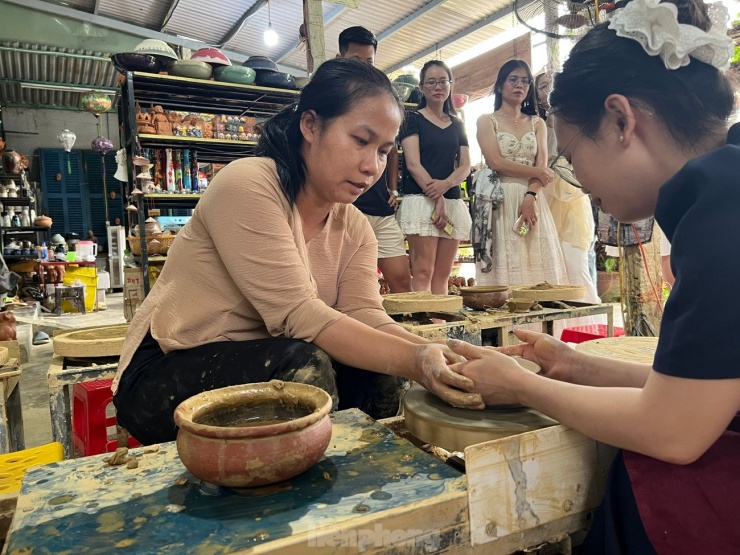 Nghệ Nhân Mỹ Linh hướng dẫn cách chuốt gốm cho những bạn trẻ: Ảnh: Văn Nhất.