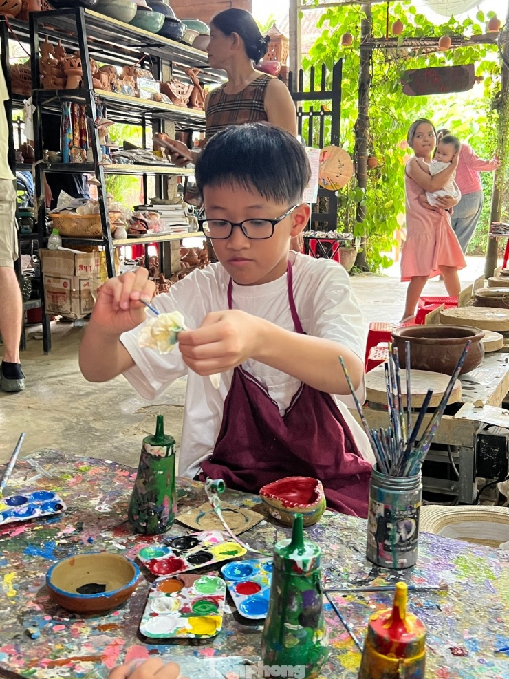 Những em nhỏ nghịch màu trên gốm. Ảnh: Văn Nhất.