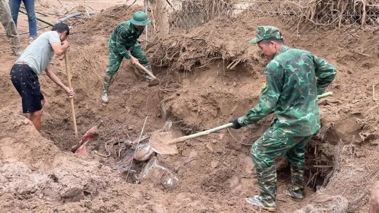 Bộ đội Biên phòng đang giúp đào bới đất tìm xe máy, tài sản cho người dân và giáo viên.