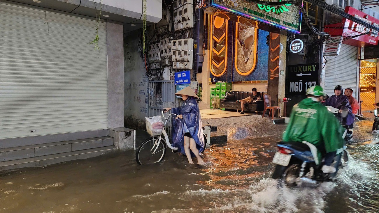 Người dân bì bõm lội nước trên phố Triều Khúc.