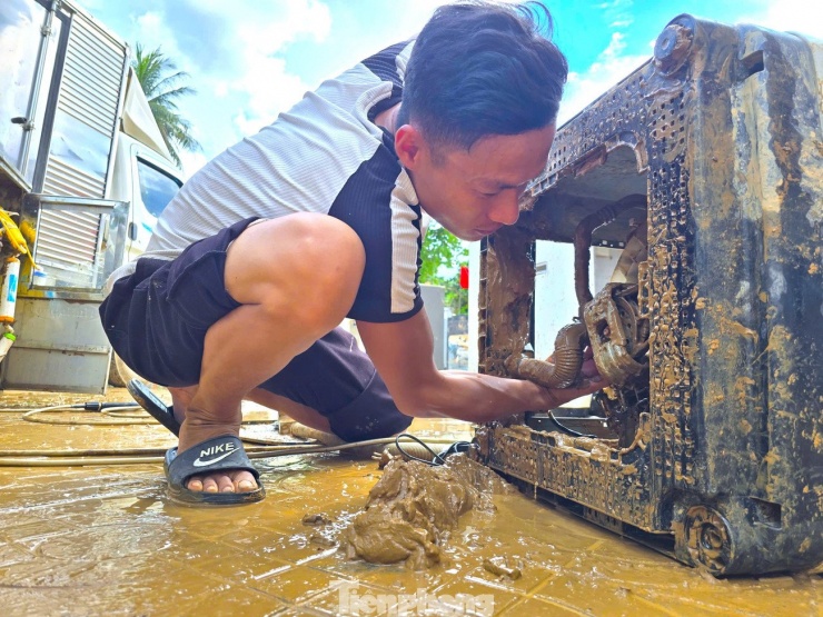 Dù đã dùng máy xịt áp suất cao nhưng lượng lớn bùn đất vẫn bám chặt bên trong buộc những người thợ phải dùng tay xử lý.