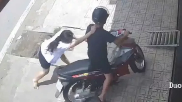 Phát hiện vụ việc, nữ nhân viên chạy theo giằng co với người đàn ông trước cửa tiệm. Ảnh cắt từ clip