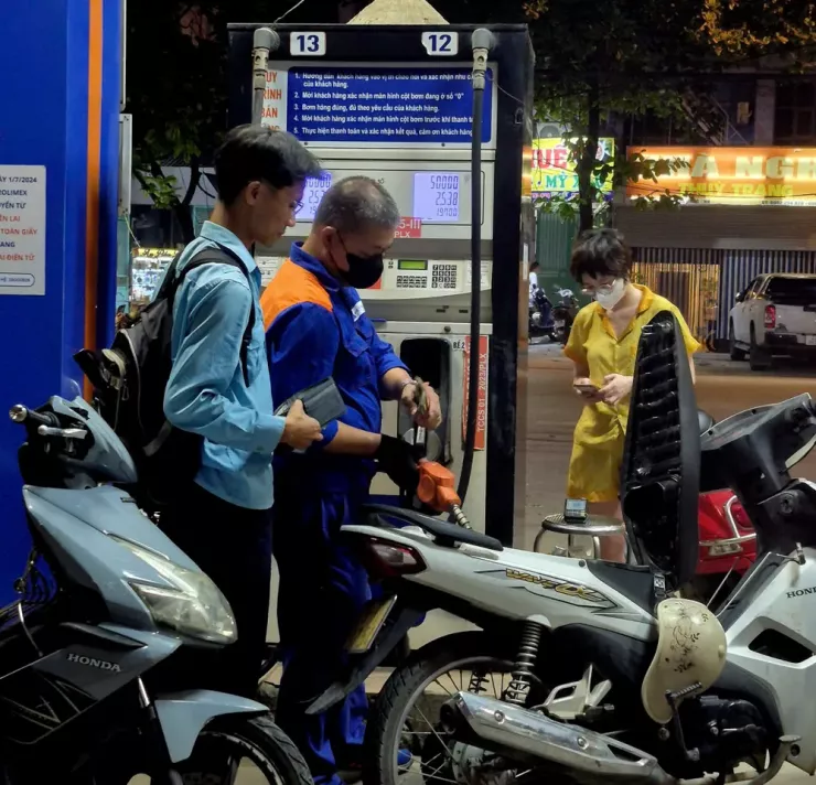 Người dân thanh toán tiền xăng tại một cửa hàng xăng dầu ở Hà Nội tối 29-7. Ảnh: AH