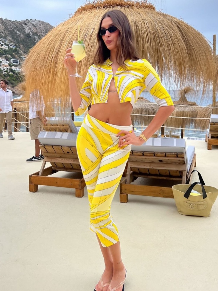 Mùa hè này, Hailey Bieber cũng sắm nhiều quần lửng khi đi nghỉ dưỡng, trong đó có mẫu màu vàng họa tiết kẻ đồng điệu crop top cộc tay. Ảnh: Instagram Hailey Bieber