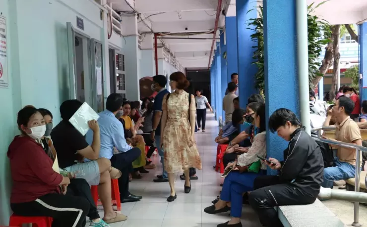 Phụ huynh và học sinh ngồi chờ nộp hồ sơ xét tuyển bổ sung vào lớp 10 tại Trường THPT Diên Hồng. Ảnh: TT