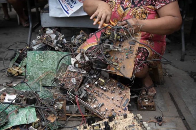 Rosalie Sedantes, vợ của Dexter Barsigan đang tháo dỡ linh kiện từ rác thải điện tử. Ảnh: AFP/ TED ALJIBE