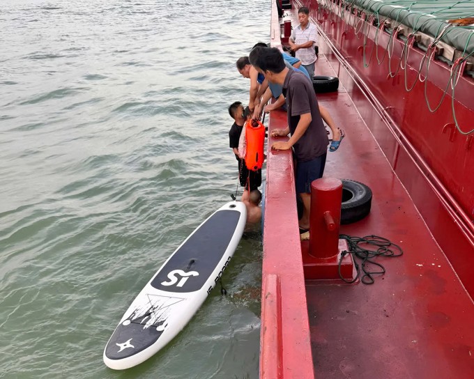 Lực lượng cứu hộ đưa bé Phương Anh từ sup lên tàu vận tải, sáng 31/7. Ảnh: Đức Long