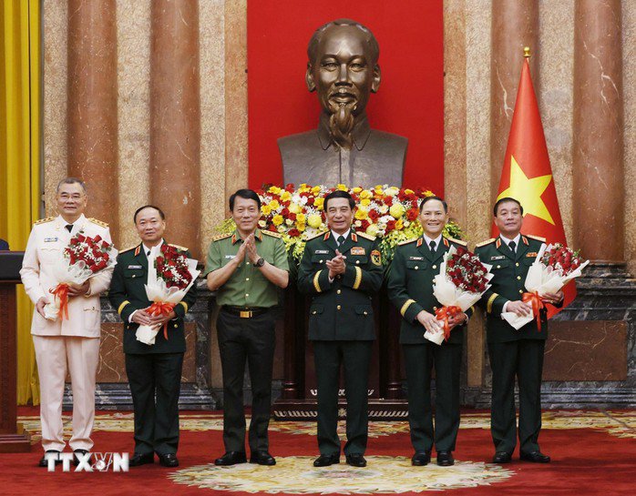 Đại tướng Phan Văn Giang, Bộ trưởng Bộ Quốc phòng và Đại tướng Lương Tam Quang, Bộ trưởng Bộ Công an, chúc mừng các đồng chí được thăng quân hàm, cấp bậc hàm Thượng tướng. Ảnh: TTXVN