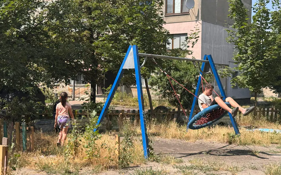 Trẻ em Ukraine ngồi xích đu ở Dobropillia trước khi cùng gia đình sơ tán. Ảnh: Telegraph.