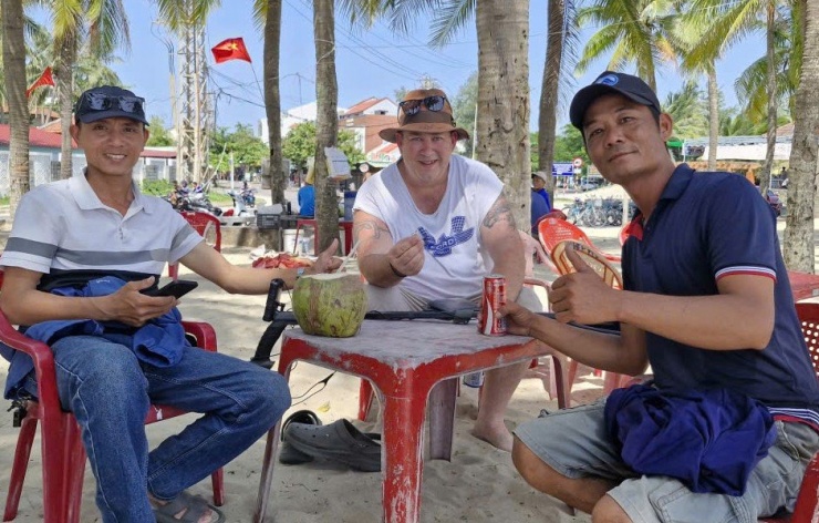 Cầm chiếc nhẫn trên tay, nam du khách vui mừng khi được anh Trinh (bìa phải) và bạn tìm giúp. Ảnh: G.X