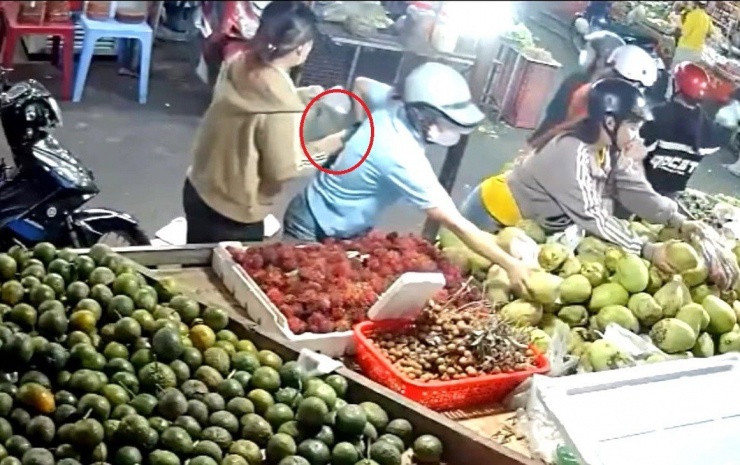 Người phụ nữ ở giữa sau khi lấy được chiếc ví đã chuyền qua tay người phụ nữ bên cạnh rồi nhanh chóng rời đi