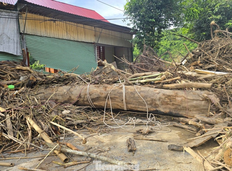Tại bản Cửa Rào (xã Tương Dương, Nghệ An), trận lũ đổ về trong đêm 22 rạng sáng 23/7 đã cuốn theo lượng lớn gỗ, củi tấp từng đống 2 bên đường, trước cổng nhà dân.
