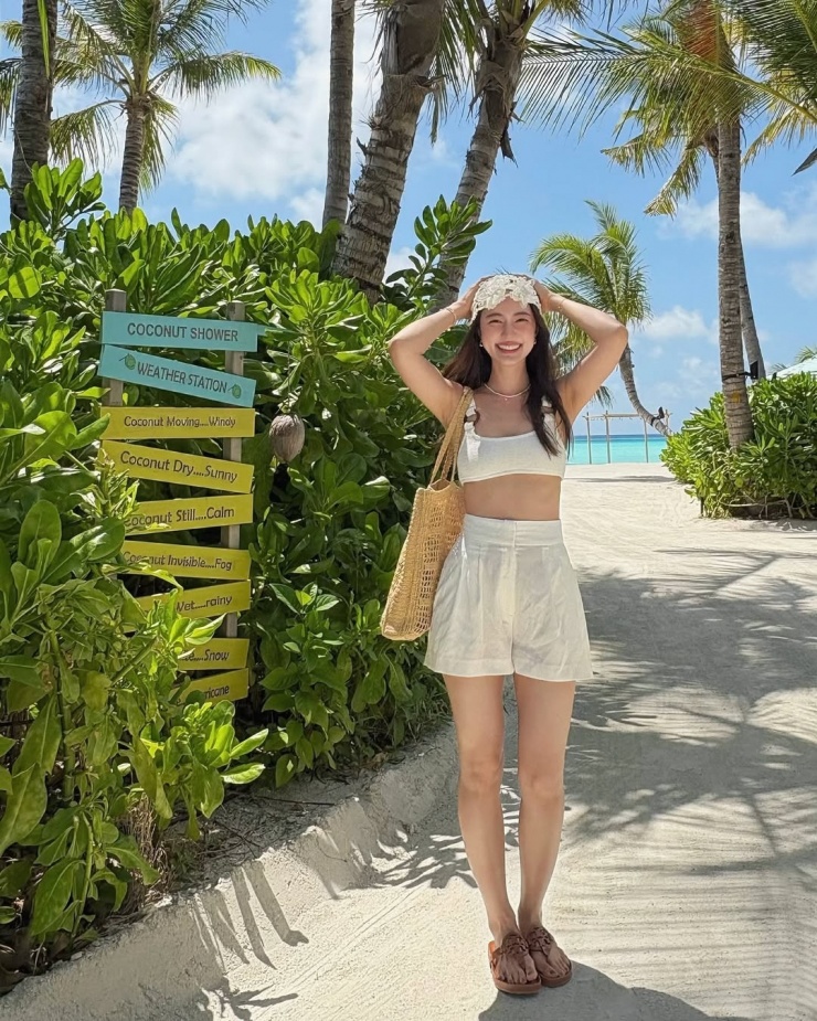 Người đẹp khoe vẻ rạng rỡ trước biển với bra, quần shorts, túi lưới, mũ cách điệu và dép xỏ ngón. Những món đồ này được tìm kiếm nhiều dịp hè nhờ sức hút của Bua Nalinthip, theo Thairath.