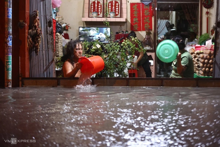 Dùng ván ngăn nhưng nước dâng cao tràn vào nhà, người dân phải túc trực dùng xô tát ra bên ngoài.