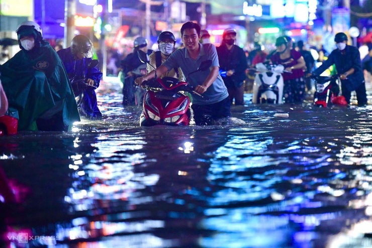 Trên đường Linh Đông giao Tô Ngọc Vân cách đó không xa cũng ngập sâu nửa mét. Nước chảy xiết làm trôi xe. Nhiều xe chết máy người dân phải dắt bộ