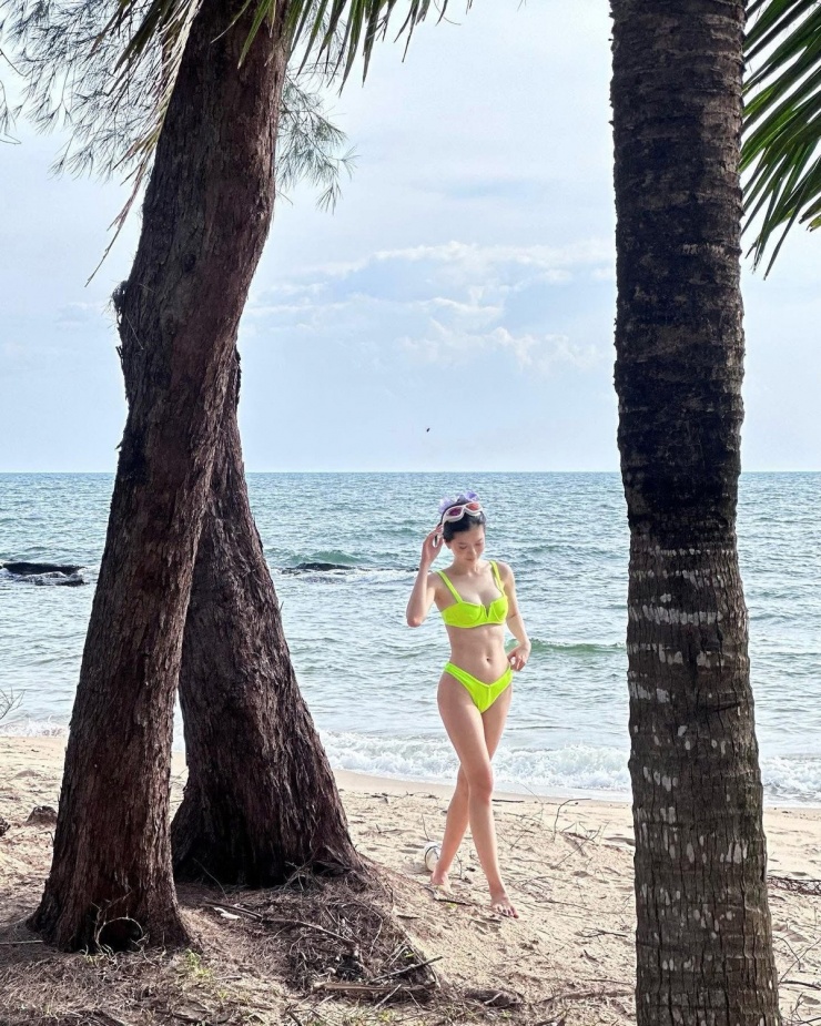 Dưới ánh nắng vàng rực rỡ và khung cảnh biển xanh cát trắng, Đỗ Yên Đan trở nên nổi bật với vẻ đẹp tươi tắn, đầy sức sống.