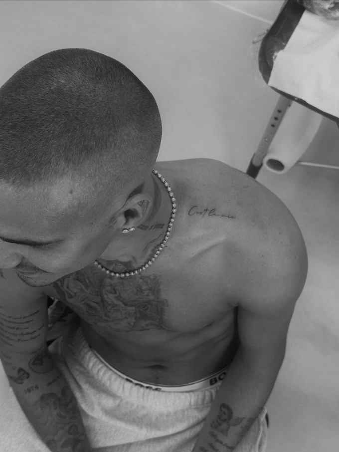 Hình xăm 'C'est la vie' trên vai Romeo được cho là ám chỉ bất hòa gia đình trong thời gian qua.