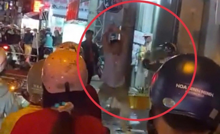 Clip ghi cảnh hai người đàn ông cầm gậy đuổi đánh nhau trên đường phố.