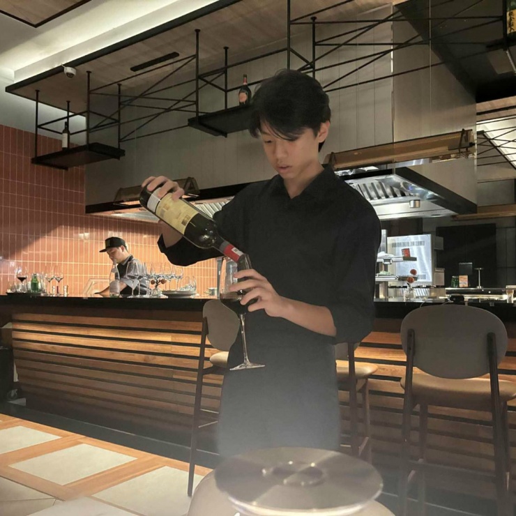 Rich kid 15 tuổi chăm chú học cách rót đồ uống tại nhà hàng.