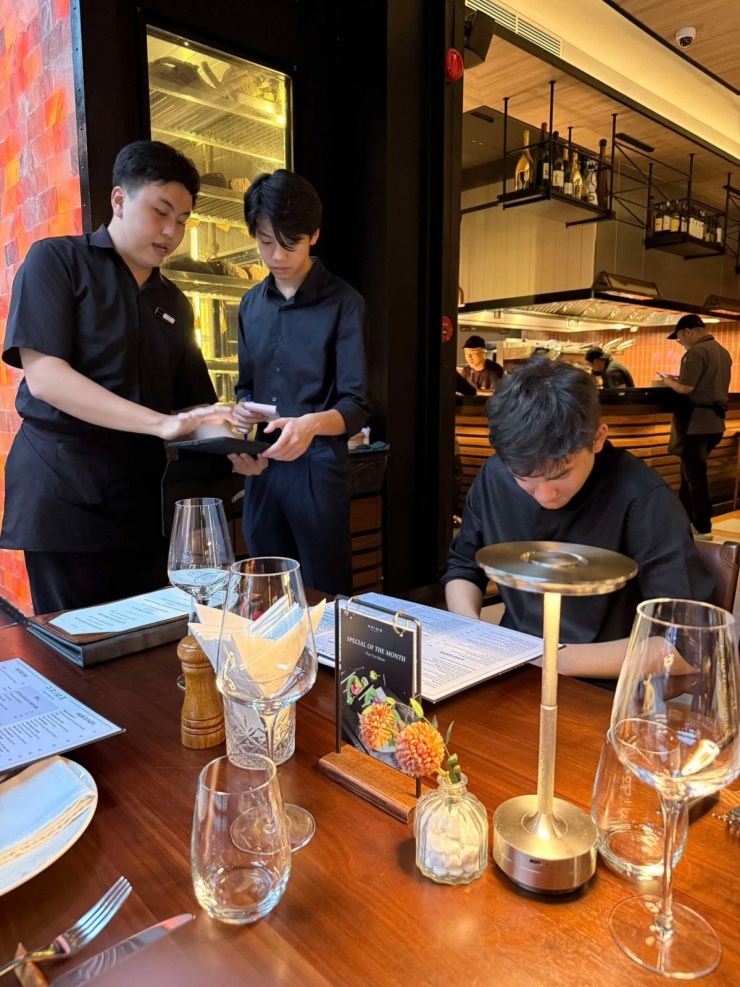 Cậu nhóc cũng được hướng dẫn quy trình nhận order, phục vụ, tính tiền... cho khách.