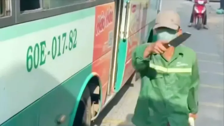Người đàn ông từ trên xe buýt bước xuống, tay cầm dao đe dọa tài xế ô tô. Ảnh: Cắt từ clip