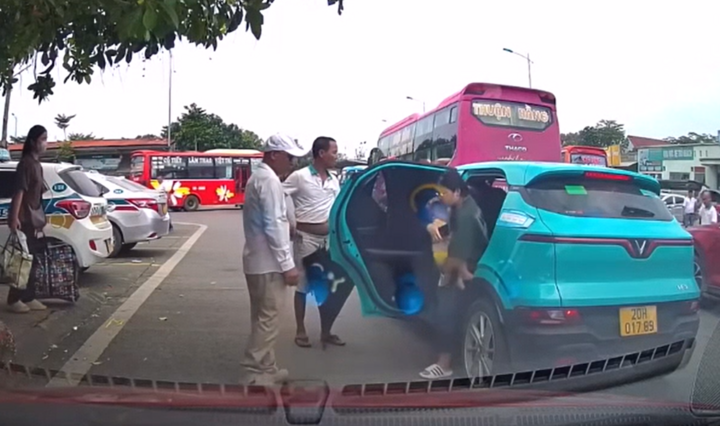 Nhóm người không cho taxi đón khách trong bến, đuổi phụ nữ bế con nhỏ ra khỏi xe. Ảnh chụp màn hình