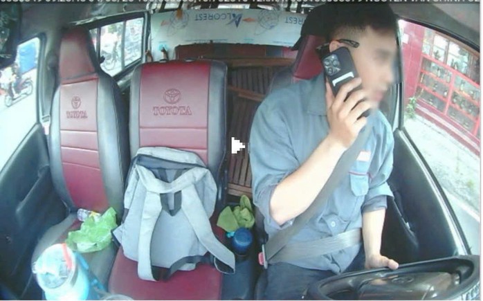 Một tài xế dùng điện thoại khi đang lái xe.