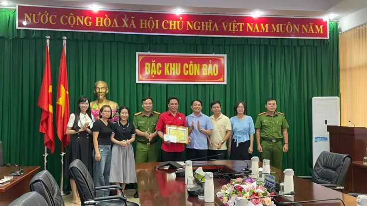 Lãnh đạo đặc khu Côn Đảo trao khen thưởng cho anh Lê Văn Tí Hon vì cùng 2 du khách dùng tay đào cứu bé trai bị vùi trong hố cát ở Côn Đảo. Ảnh: LÝ HUYỀN