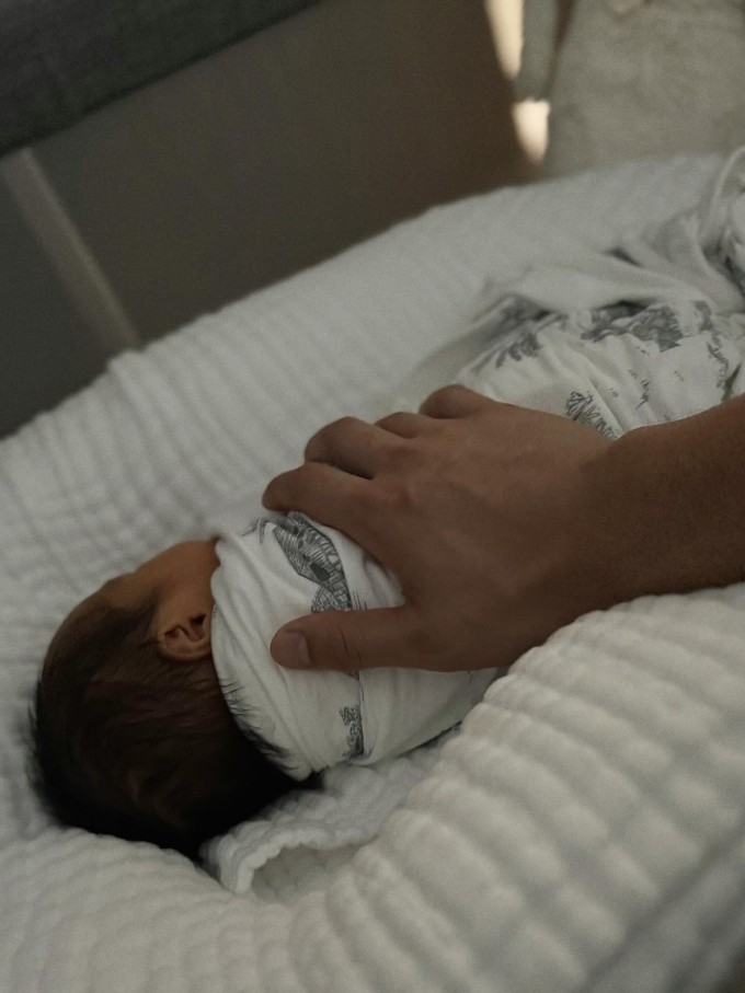 Em bé Gạo nằm gọn trong bàn tay cha.