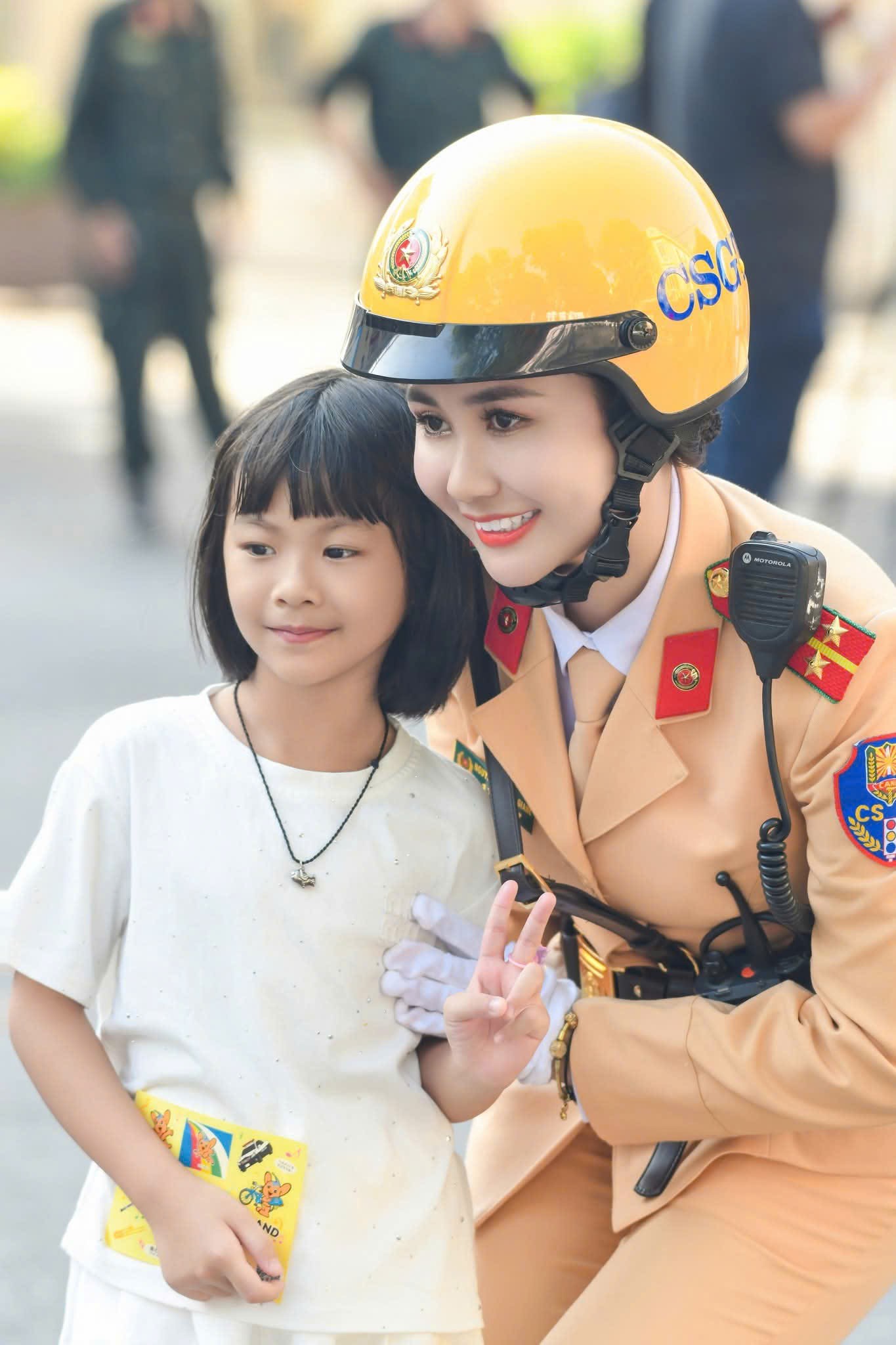 Rất đông người dân đã có mặt để theo dõi sự kiện. Các em nhỏ  thích thú chụp ảnh lưu niệm cùng nữ cảnh sát giao thông.