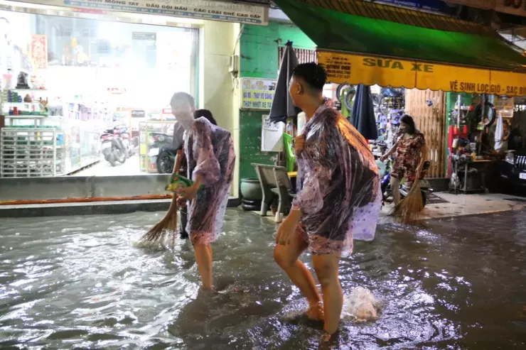 Người dân vất vả dọn nhà sau cơn mưa lớn.