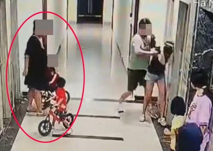 Người phụ nữ mặc váy đen chứng kiến hành vi bạo lực từ đầu đến cuối nhưng không can ngăn. Ảnh cắt từ clip