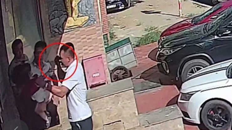 Hình ảnh người đàn ông mặc áo trắng đấm vào người anh T.