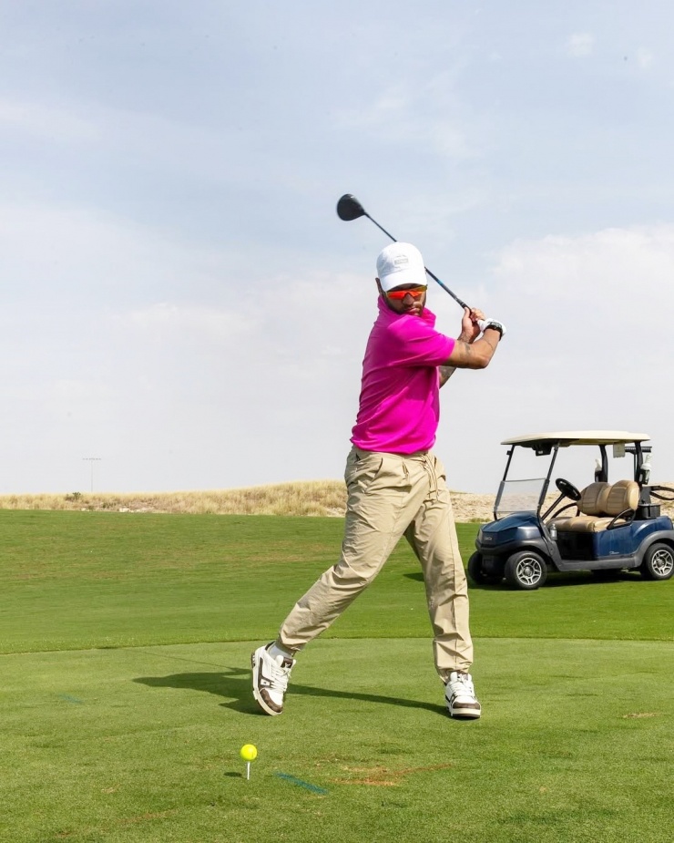 Trong lần đi đánh golf, cầu thủ phối giày Louis Vuitton và quần bo chun, tạo điểm nhấn với áo hồng cánh sen và kính mát cách điệu.