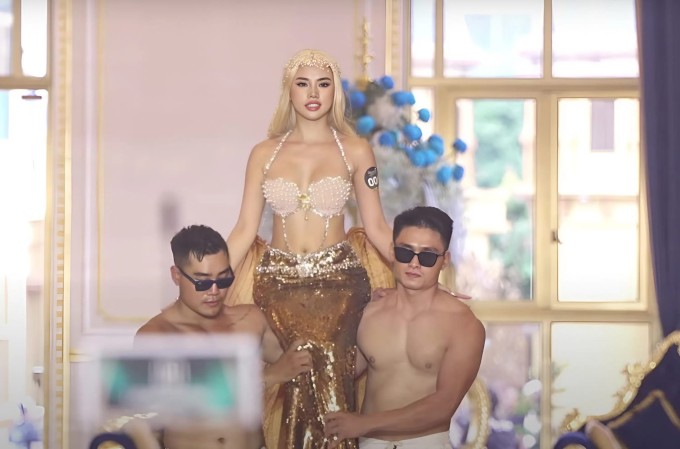 Thí sinh hóa Nàng tiên cá, được hai mỹ nam bế ra sân khấu.