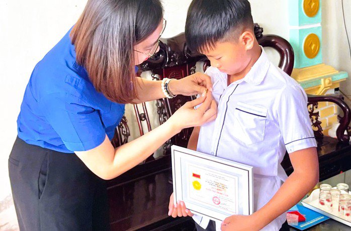 Phó Bí thư Tỉnh đoàn Ninh Bình Lê Thị Mai Phương trao Huy hiệu "Tuổi trẻ dũng cảm" cho nam sinh lớp 6 lao xuống mương nước cứu người gặp nguy hiểm. Ảnh: Tỉnh đoàn Ninh Bình