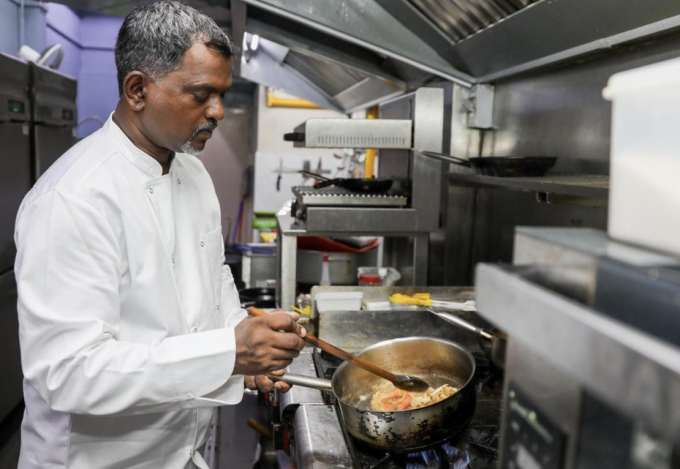 Ông Rathakrishnan Ramaiyan, 56 tuổi, đang nấu ăn trong căn bếp ở Singapore. Ảnh: ST