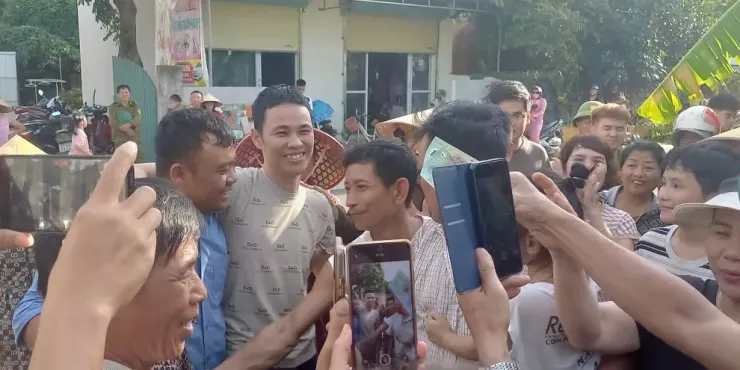 Anh Thành trong vòng tay người dân khi về đến đầu ngõ.