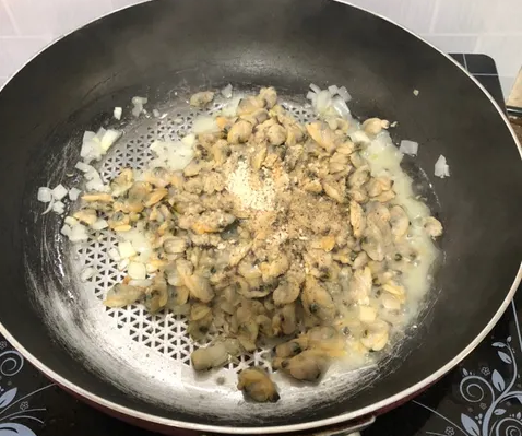 Dầu nóng cho hành tây băm vào xào thơm, cho nghêu vào xào với mắm &amp; hạt nêm.